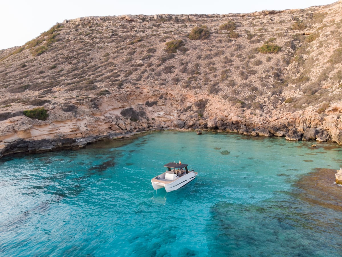 Mobula anchored in a crystal-clear cove below the cliffs