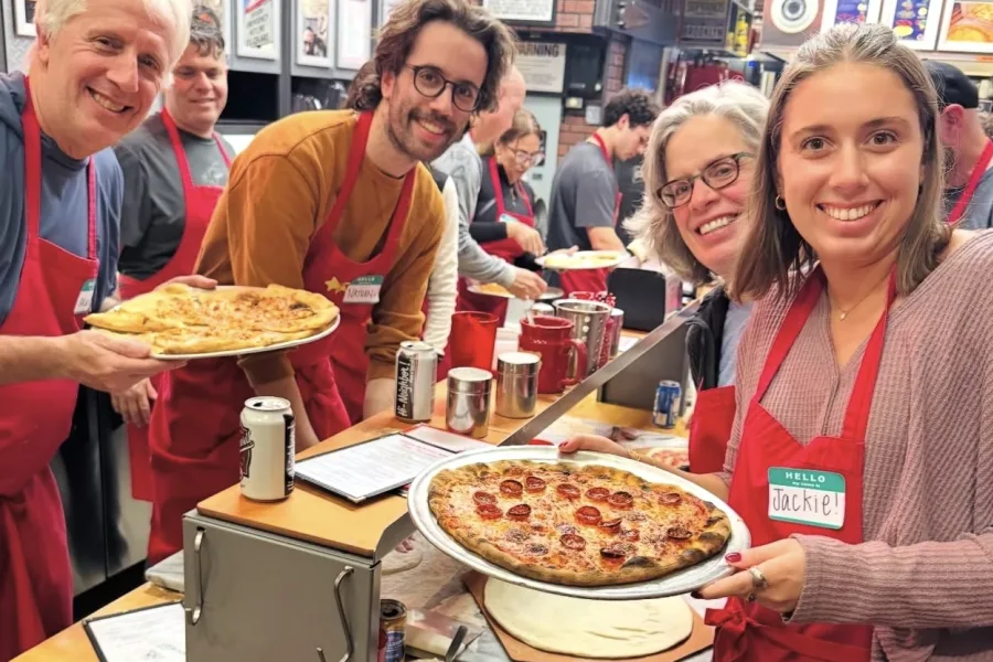 Group of four posing with their pizzas during NYC Pizza-Making Workshop