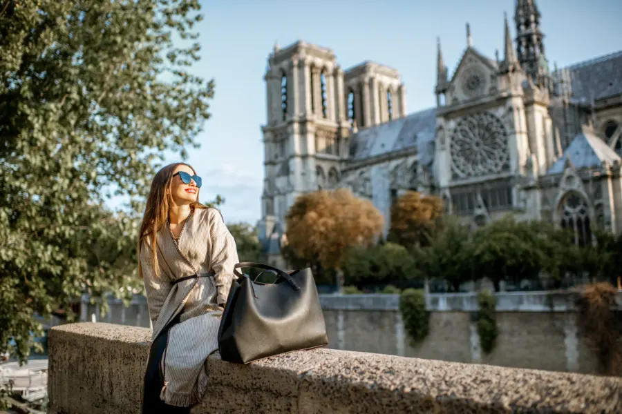 Tourist sitting near the famous Notre-Dame cathedral in Paris, France