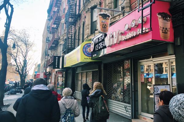 A group in front of the ViVi bubble tea shop at the Food On Foot Go West Guided Tour