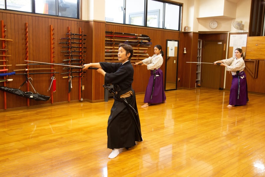 Instructor teaching stage combat choreography with samurai swords during Samurai Dojo & Shinto Shrine Experience