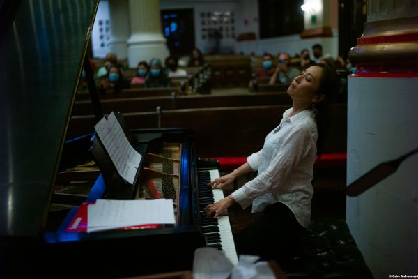 A lady playing the piano on the Harlem Gospel Series