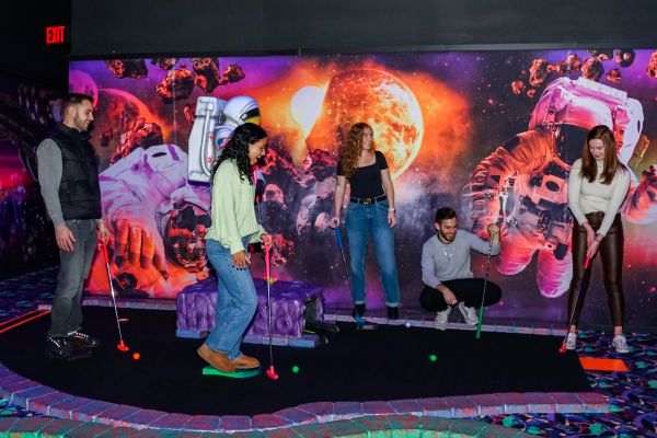 A group on the Black Light Mini Golf