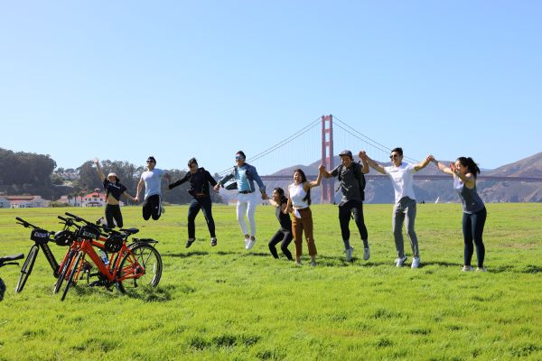A group jumping at the Golden Gate Bridge All Day Bike Rental