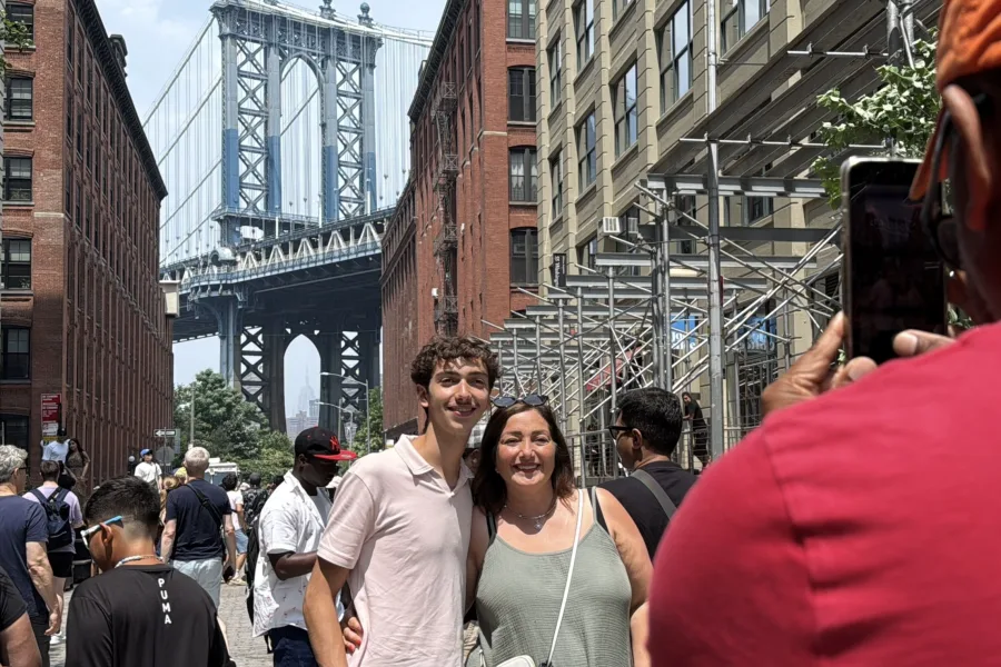 Two people taking a photo with Brooklyn Bridge during Beyond Manhattan private guided tour
